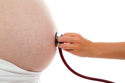 Childs hand with stethoscope on pregnant belly over white background