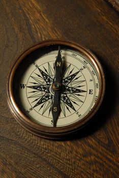 Old compass on the background of brown boards