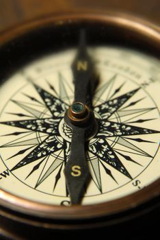 Old compass on the background of brown boards