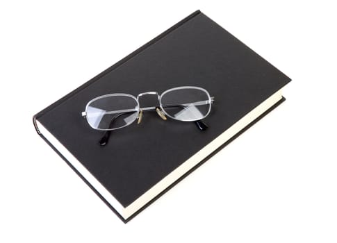 book with reading glasses isolated on white background