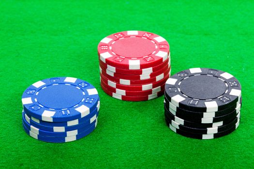 piles of colorful casino chips on green table