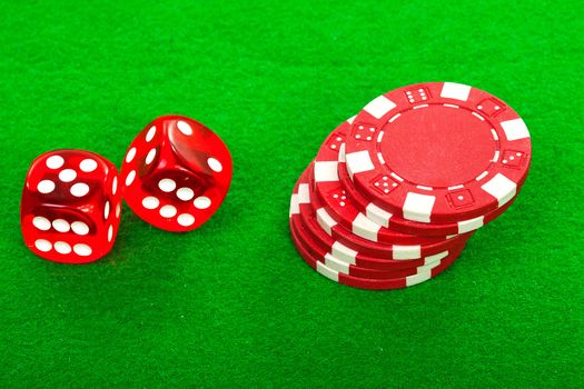 casino chips and red dices over green background