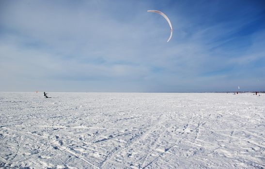 Winter kite skiing on the frozen river