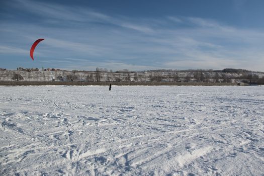 Winter kite skiing on the frozen river