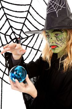 Portrait of green Halloween witch girl holding big blue marble