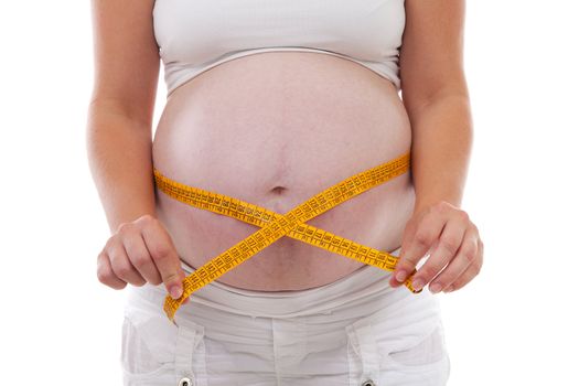 Measuring pregnant belly in closeup over white background