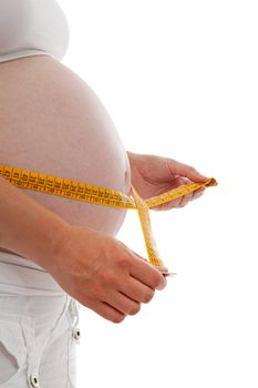 Measuring pregnant belly in closeup over white background