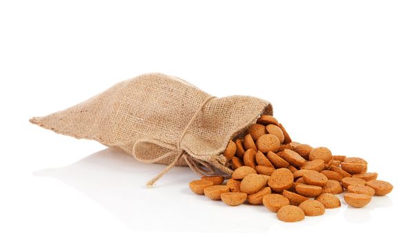 jute bag with ginger nuts (pepernoten) Dutch tradition for Sinterklaas over white background