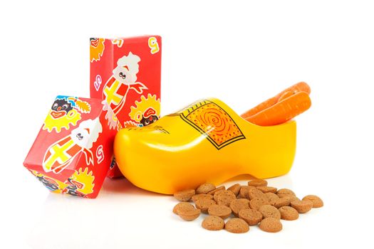 Dutch wooden shoe with presents and pepernoten over white background