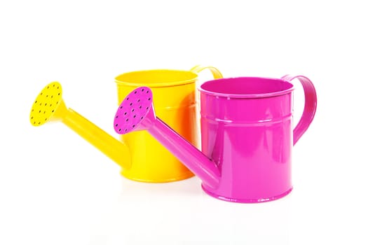 Two colorful watering cans over white background