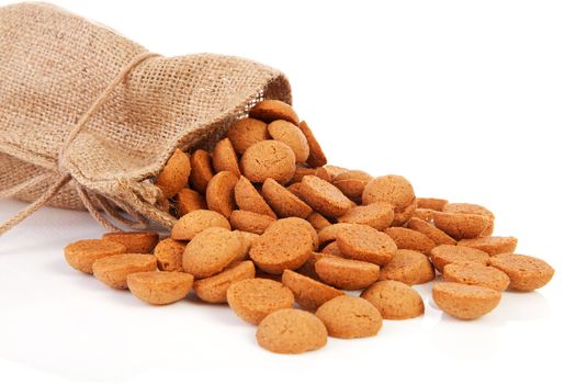 jute bag with ginger nuts (pepernoten) Dutch tradition for Sinterklaas over white background