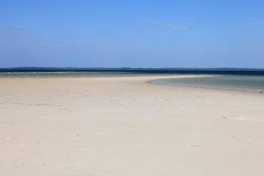 Empty tropical beach with foot steps in the sand