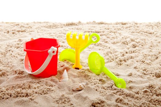 plastic play toys on sand over white background