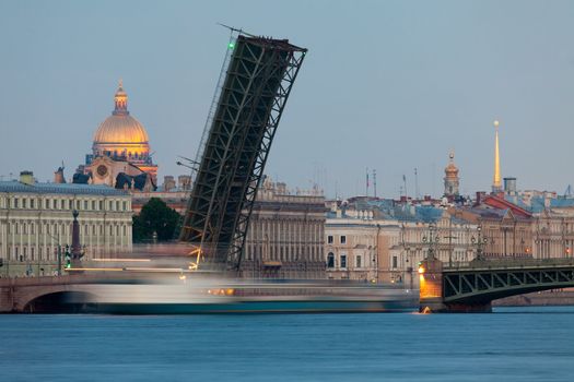 Beautiful view of St. Petersburg White Nights - open Foundry bridge with passing beneath the ship, the Marble Palace and St. Isaac's Cathedral. Russia.
