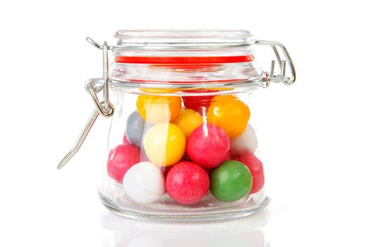 pot with colorful gumballs over white background