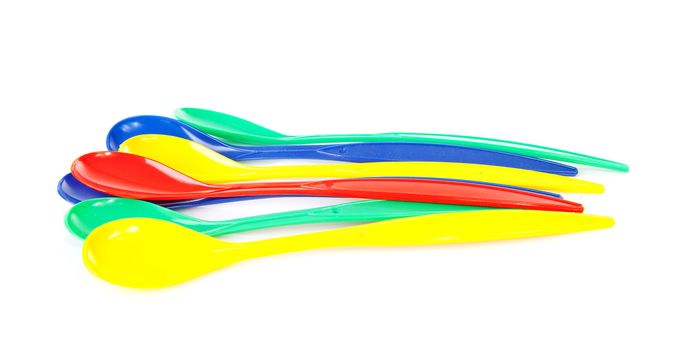 pile of colorful plastic spoons over white background