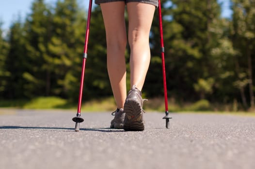 Closeup of woman's legs with nordic walking poles