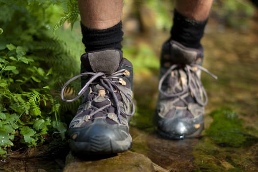 Closeup of a hiking boots over a stream