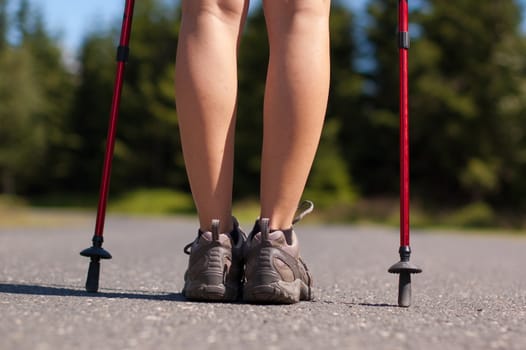 Closeup of woman's legs with nordic walking poles