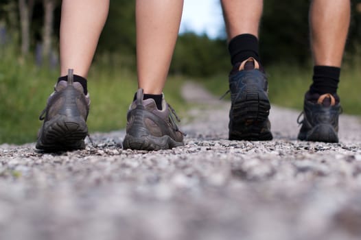 Closeup of a two pairs of hiking boots on trail