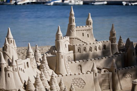 creative big sandcastle on the beach in summer blue sky