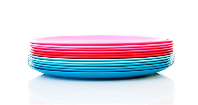 Pile of colorful plastic plates over white background