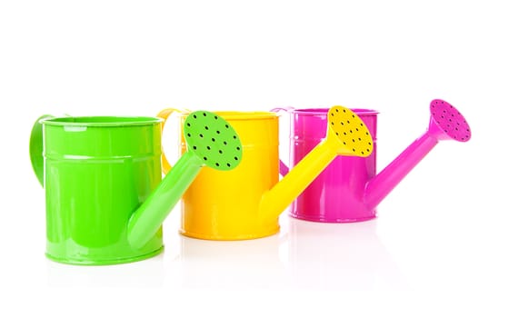 Three colorful watering cans over white background