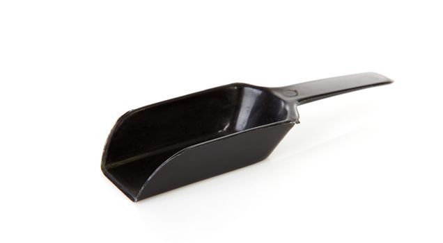 Black plastic measuring spoon over white background