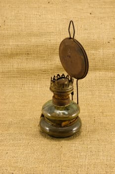 rusty retro paraffin lamp on burlap rural background.