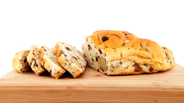 slices of raising bread on wooden cutting board over white background 
