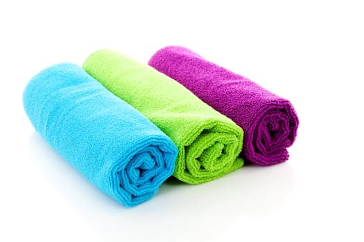 Three colorful rolled towels over white background