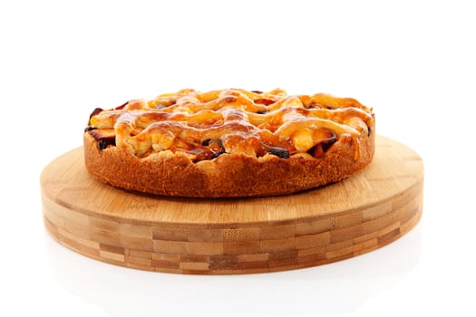 Delicious home baked apple pie on wooden cutting board isolated on white background