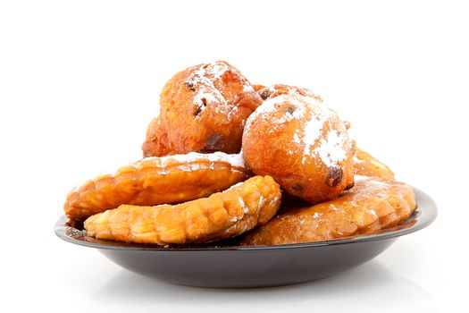 Plate with Dutch donut also known as oliebollen and apple turnovers, traditional New Year's eve food isolated on white background