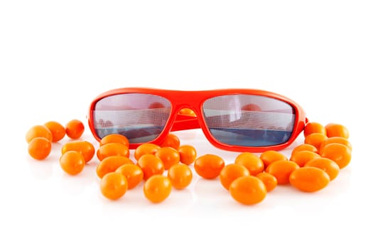 Sunglasses with Dutch flag and orange candy over white background