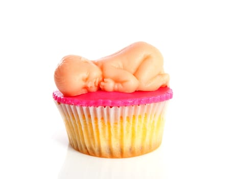 Pink Birth cupcake with marzipan baby over white background