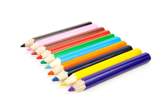 colorful pencils in a row over white background