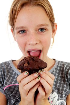 Girl is eating big chocolate cupcake over white background