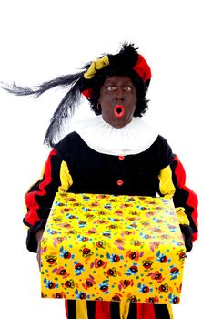 Zwarte piet ( black pete) typical Dutch character part of a traditional event celebrating the birthday of Sinterklaas in december over white background with big present