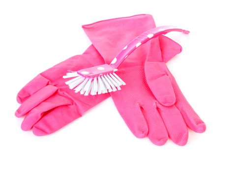 pair of pink household gloves and dish brush over white background