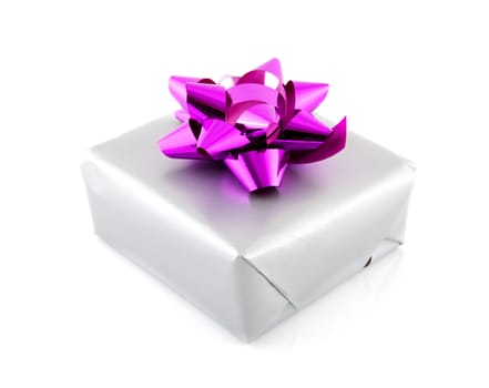 Present wrapped in silver paper and pink ribbon over white background