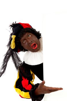 Zwarte piet ( black pete) typical Dutch character part of a traditional event celebrating the birthday of Sinterklaas in december over white background is holding empty text board