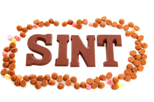 The word "Sint" in chocolate lettersand ginger nuts ( pepernoten)  isolated on white background, typical Dutch candy for Sinterklaas event in december