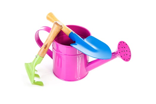 Colorful gardening tools over white background; watering can, shovel and rake