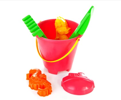 Plastic beach toys in bucket over white background