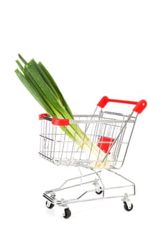 Shopping cart with spring onions over white background