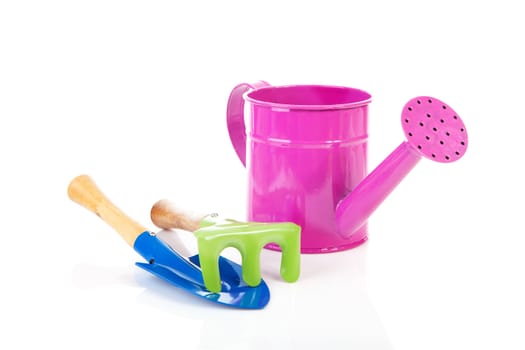 Colorful gardening tools over white background; watering can, shovel and rake