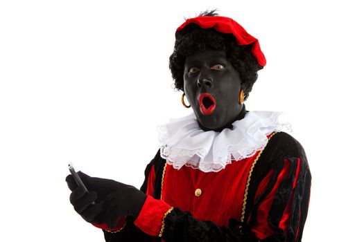 Zwarte piet ( black pete) typical Dutch character part of a traditional event celebrating the birthday of Sinterklaas in december over white background with mobile phone