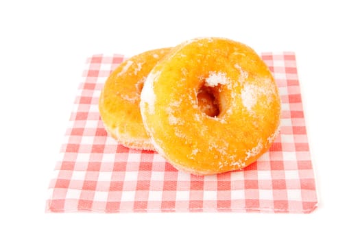 two sugared delicious donuts in napkin over white background