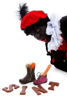 Sinterklaas, typical Dutch event with zwarte piet ( black pete) chocolate letters and carrot in shoes over white background