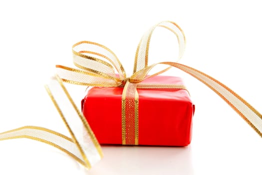 Red present with golden bow over white background